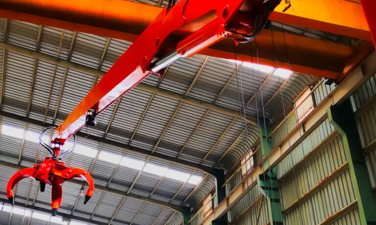 How does a Stationary Mounted Crane with Grapple compare to a Loader Tractor in terms of performance, cost efficiency, maintenance requirements, and suitability for heavy-duty stationary tasks?
